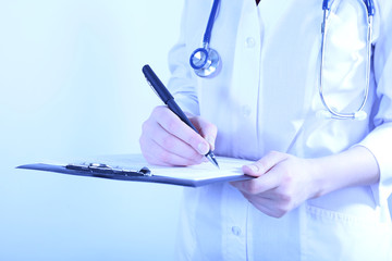 Doctor writing on clipboard on light background