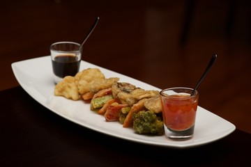 Tempura vegetable platter with glasses of sauce