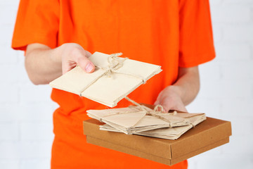Courier with parcel box and letters close-up