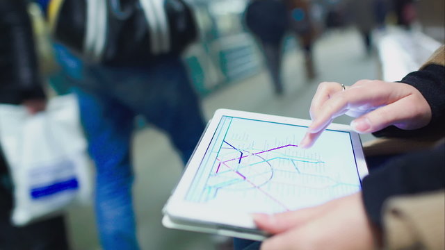 Woman searching station on underground map using touch pad