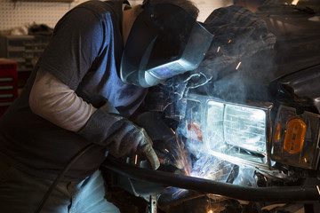 Man welding the bumper of a vehicle