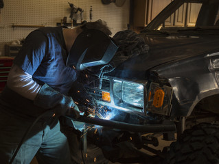 Man welding the bumper of a vehicle