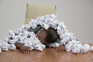 Business woman covered in crumpled papers