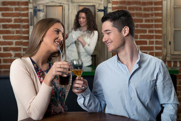 Smiling couple on a date at a bar.