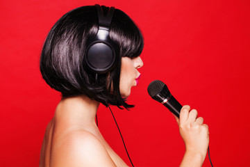 Woman listening to music on headphones enjoying a singing