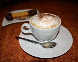 Delicious foamy cappuccino on the wooden table