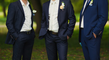 three groomsmen at a wedding in the green park