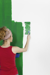 Frau streicht Wand gruen