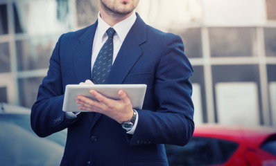 Businessman holding a digital tablet computer, standing in front