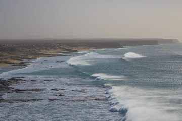 Surfing in strong waves on the surfing beach in El Cotillo Fuert