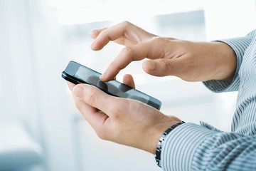 Close up of a man using mobile smart phone