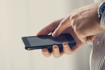 Close up of a man using mobile smart phone