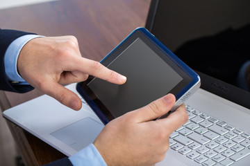 Businessman working on laptop and tablet