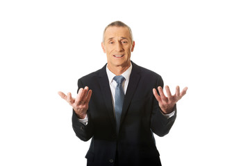 Businessman with open hands in undecided gesture