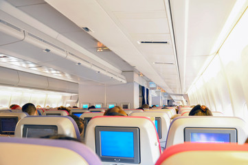 Airplane seats in the cabin with personal TV on board 