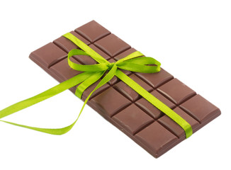 bar of chocolate and green ribbon isolated on white background