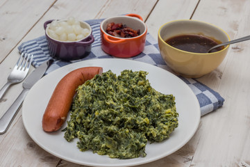 Boerenkool with smoked sausage on a white plate