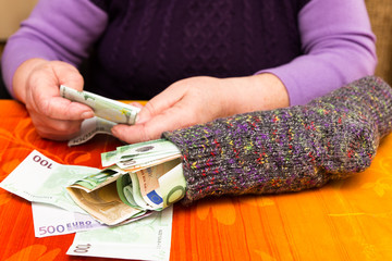 Seniorin zählt Geld im Sparstrumpf