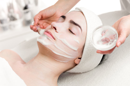Young woman peeling foam mask applying on face
