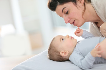 Obraz na płótnie Canvas Mommy cuddling baby boy on changing table