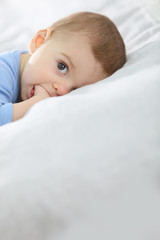 8-month-old baby boy laying on bed