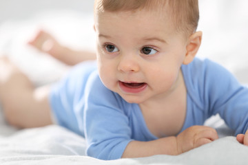 8-month-old baby boy laying on bed