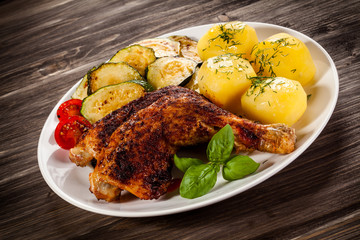 Barbecued chicken leg with boiled potatoes and vegetables