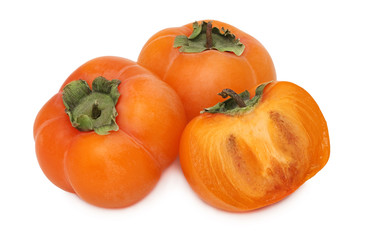 Two whole and a half of ripe persimmon with green leaves (isolat
