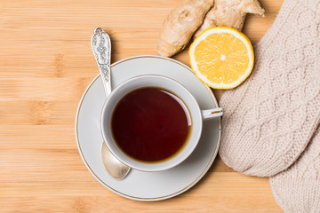 Cup of tea with honey,  ginger and lemon on wooden table
