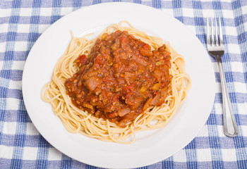 Plate of Spaghetti and Meat Sauce on Blue Plaid Placemat
