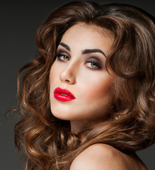 Fototapeta premium Beautiful woman with magnificent curly hair. Red lipstick.