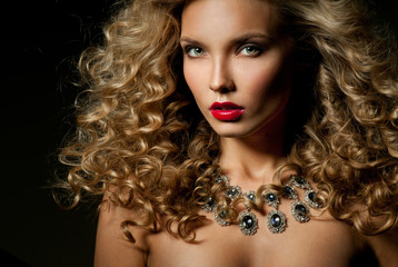Beautiful woman with magnificent curly hair. Red lipstick. Neckl