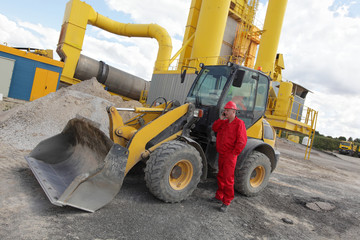 worker in red uniform on phone at  buldozer