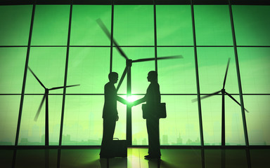 Green business shake hand silhouette with windmill.