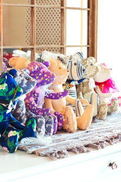 Many tilda textile teddy bear toys in workshop.