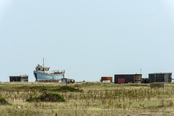 Fototapeta na wymiar fish boat aground and sheds at Dungedness