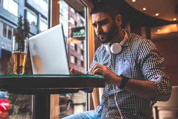Young man sitting at cafe and using laptop.