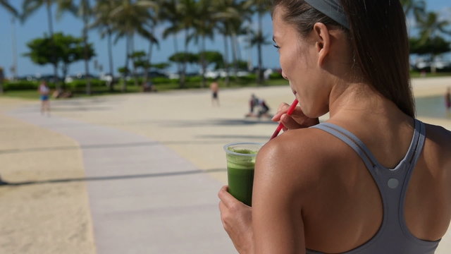 Woman drinking vegetable Green detox smoothie