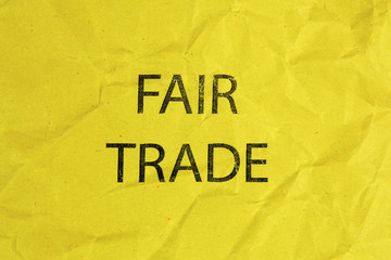 fair trade text on yellow crumpled paper