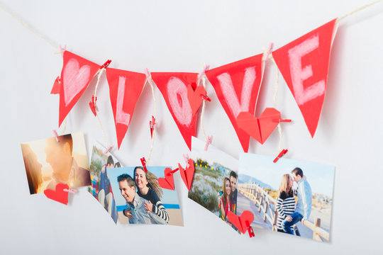 Wall with pictures and garland hanging on clothesline