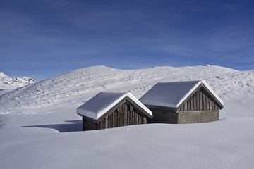 Alpine huts in snowy mountain landscape