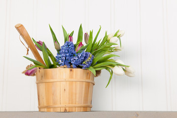 Colorful bouquet spring flowers in wooden bucket