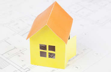 Paper model of the house costs on the construction plan