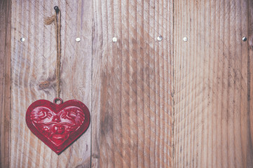Coeur rouge en métal sur du bois