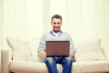 smiling man working with laptop at home