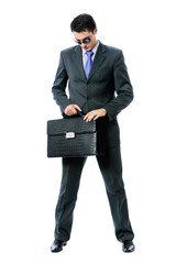 Businessman or hacker in sun glasses with briefcase, isolated