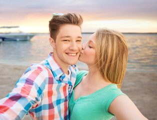 happy couple taking selfie on summer beach