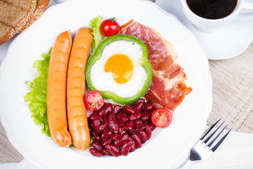 Egg fried in a green pepper, sausages, bacon and red beans