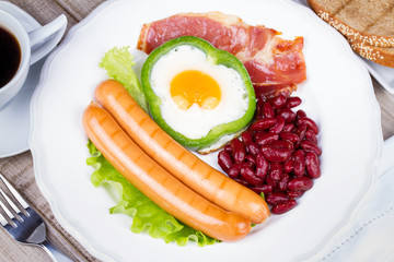 Egg fried in a green pepper, sausages, bacon and red beans