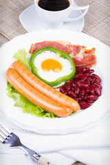 Egg fried in a green pepper, sausages, bacon and red beans